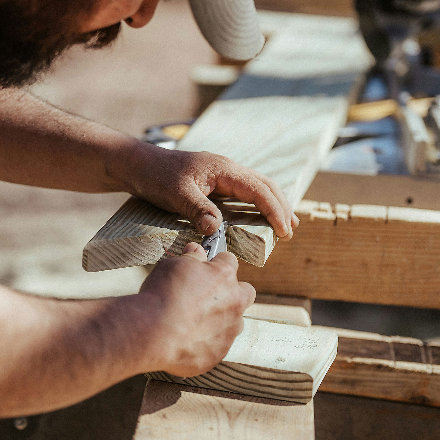 Gewerbeverein-Bad-Wimpfen-Schreiner Handwerker Gewerbeverein Bad Wimpfen Hände eines Mannes mit einem Cuttermesser an einer Holzlatte