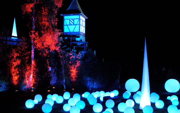 Bunt angestrahlte Stadtmauer mit Turm und runde Lichtelemente Kunstnacht Bad Wimpfen