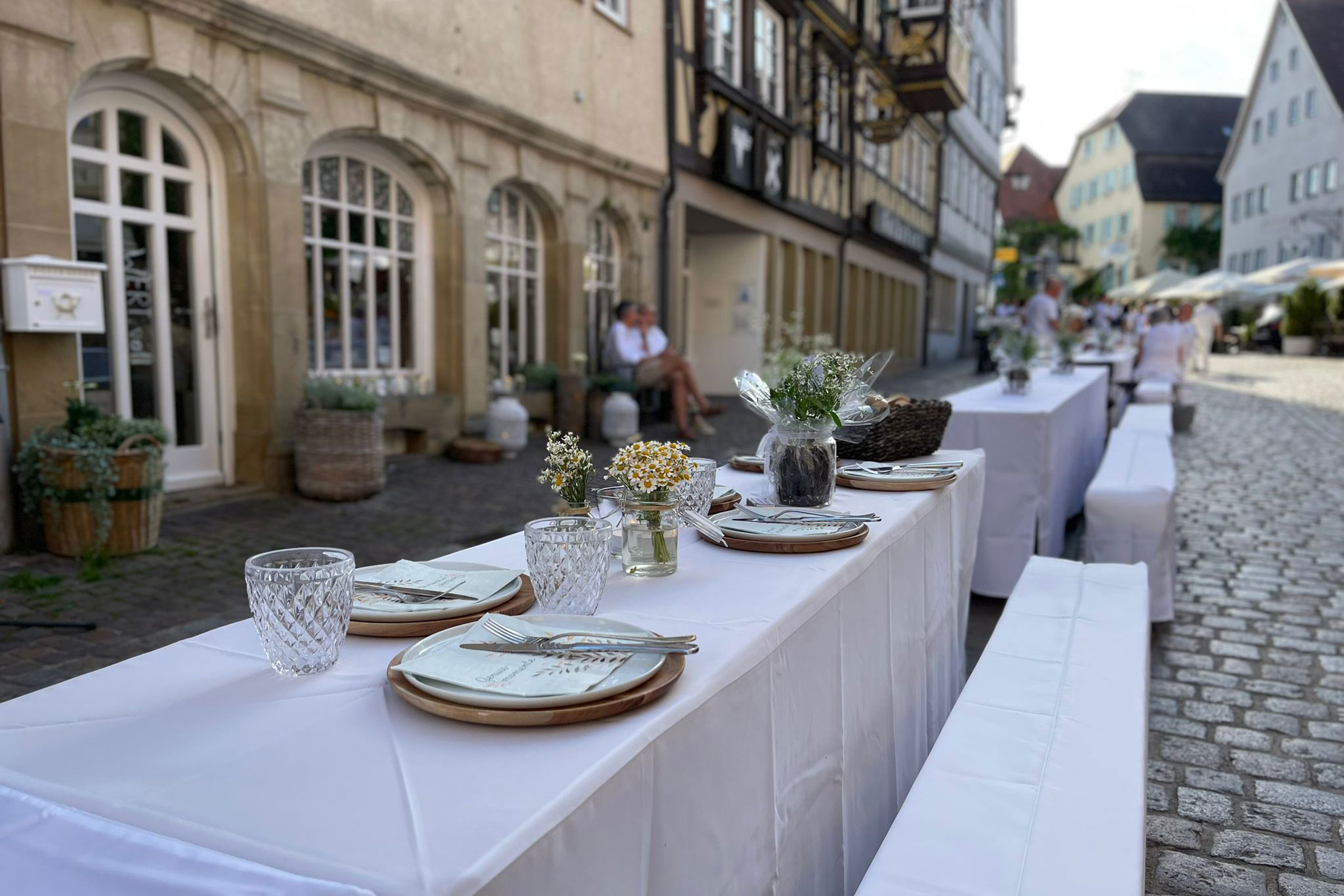 weiss gedeckte lange Tafel in der Altstadt Bad Wimpfen für die Weiße Nacht-Veranstaltung Gewerbeverein Bad Wimpfen